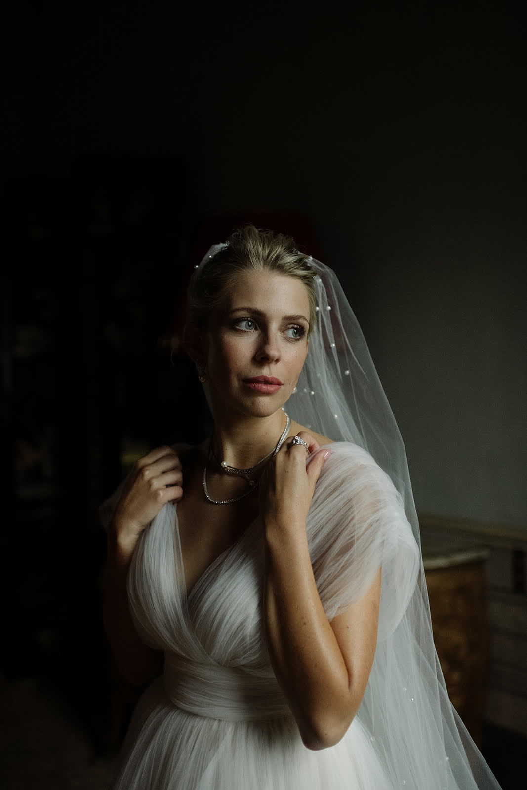 Bride by the window holding her veil